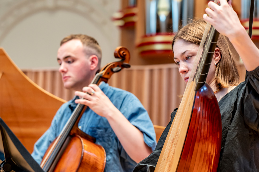 Two students performing the cello and lute in a rehearsal.